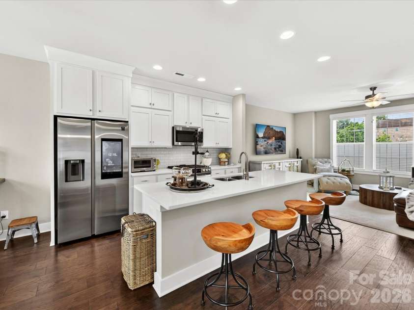 546 Amalfi Drive, Davidson, NC 28036.  MLS# CAR4390990, YatesRealty ID 32467. The beautifully appointed kitchen features quartz counters, crisp white shaker cabinetry, stainless steel appliances, a gas range, and an oversized island with seating, creating the perfect space for cooking, gathering, an
