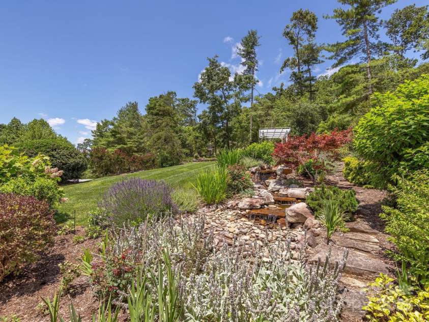 446 Charming Lane, Hendersonville, NC 28792.  MLS# CAR4287765, YatesRealty ID 32506. Breathtaking mature landscaping and water feature