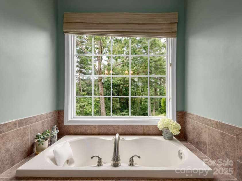 446 Charming Lane, Hendersonville, NC 28792.  MLS# CAR4287765, YatesRealty ID 32506. Relax in the jacuzzi tub framed by views of surrounding trees