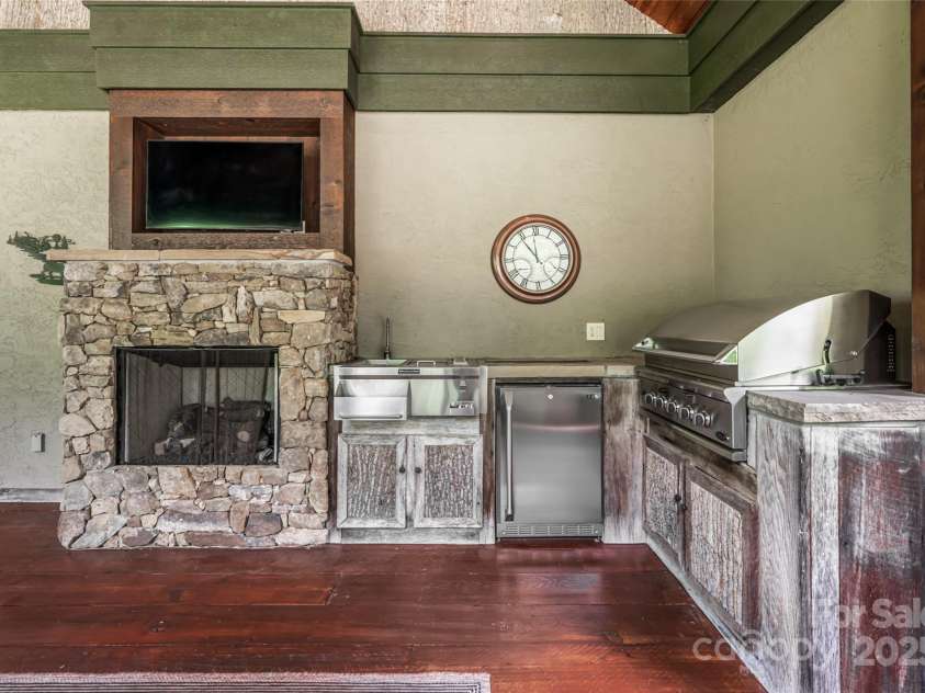 97 Lombard Street, Waynesville, NC 28786.  MLS# CAR4282341, YatesRealty ID 32568. Summer Kitchen with built in grill, sink, outdoor gas fireplace and TV