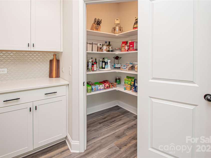1061 Ansley Park Drive, Fort Mill, SC 29707.  MLS# CAR4281028, YatesRealty ID 32626. Enjoy a spacious pantry with custom shelving, offering smart and stylish storage for all your kitchen essentials.