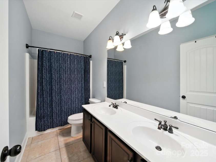 1402 Wynhurst Drive, Waxhaw, NC 28173.  MLS# CAR4290603, YatesRealty ID 32635. Hall bathroom with dual sinks and shower/tub combo.