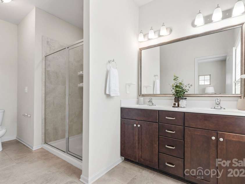 9324 Ainslie Downs Street, Charlotte, NC 28273.  MLS# CAR4276597, YatesRealty ID 32727. Primary bathroom with double vanity and standing shower