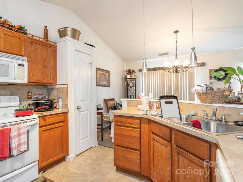 7941 Mossycup Drive, Charlotte, NC 28215.  MLS# CAR4292875, YatesRealty ID 32751. Kitchen into Dining