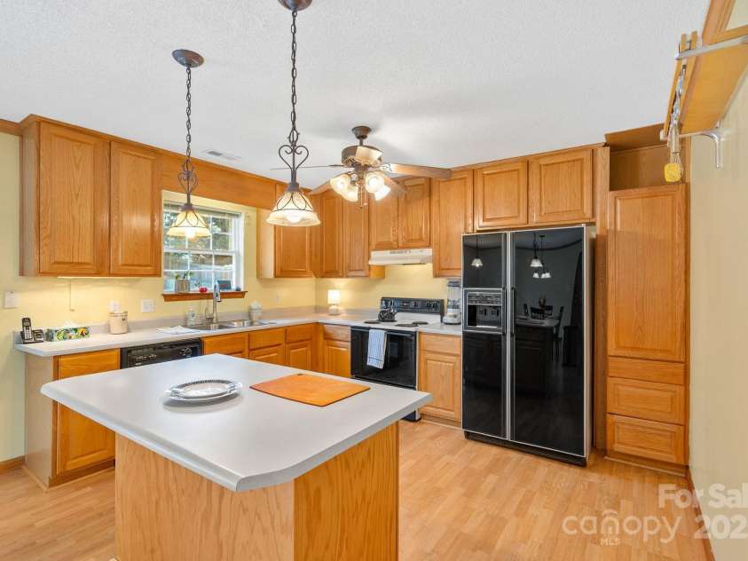 27 Eden Glen Road, Black Mountain, NC 28711.  MLS# CAR4292054, YatesRealty ID 3277. A light-filled kitchen with island workspace and convenient flow to the dining area.