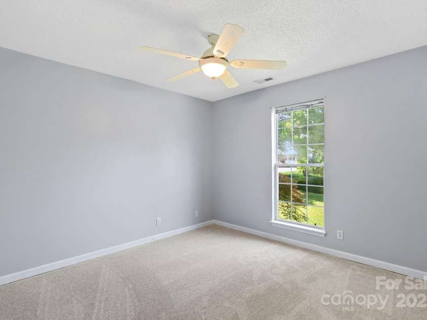 27 Eden Glen Road, Black Mountain, NC 28711.  MLS# CAR4292054, YatesRealty ID 3277. Inviting bedroom with a ceiling fan, neutral palette, and plenty of natural light.