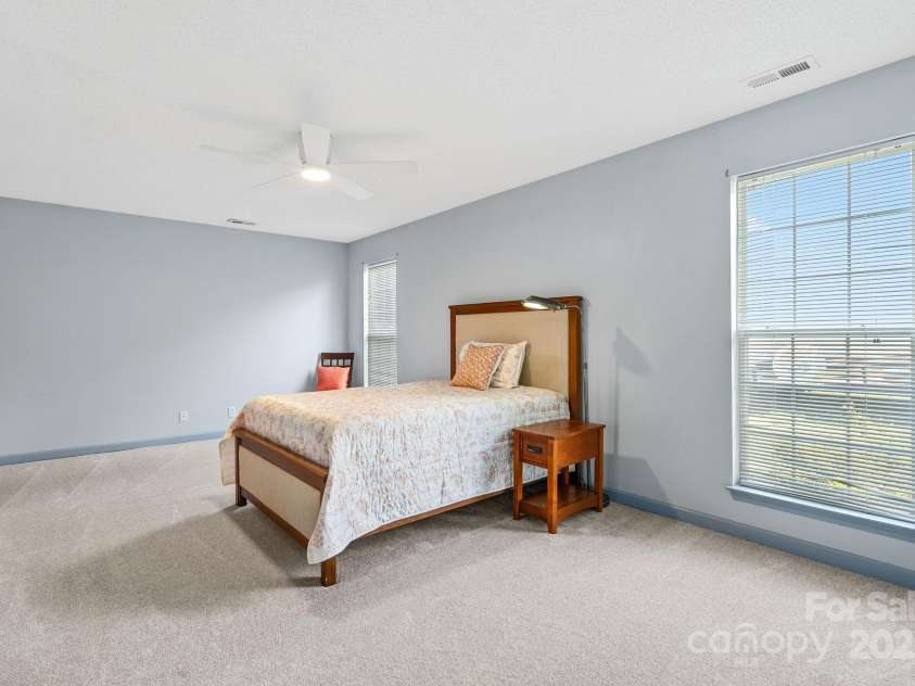 27 Eden Glen Road, Black Mountain, NC 28711.  MLS# CAR4292054, YatesRealty ID 3277. This expansive primary bedroom—nearly 20 ft by 12 ft—offers plenty of room for a king-size bed, additional furniture, or even a cozy sitting area. With fresh carpet, neutral tones, and abundant natural light, it’s a 