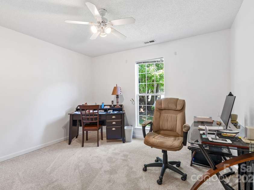 27 Eden Glen Road, Black Mountain, NC 28711.  MLS# CAR4292054, YatesRealty ID 3277. This third bedroom offers versatility—ideal as a home office, hobby space, or guest room. A large window fills the room with natural light, while neutral walls and fresh carpet create a clean, inviting backdrop.