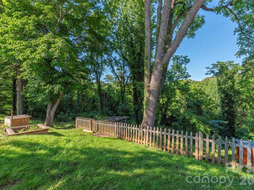 261 Star Ridge Road, Canton, NC 28716.  MLS# CAR4396365, YatesRealty ID 32791. A raised garden bed and established trees create a peaceful backyard setting.