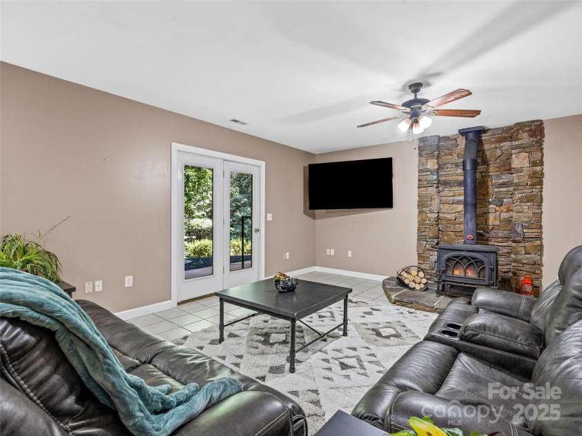 247 Big Raven Lane, Saluda, NC 28773.  MLS# CAR4272997, YatesRealty ID 32851. Lower level living room with fireplace