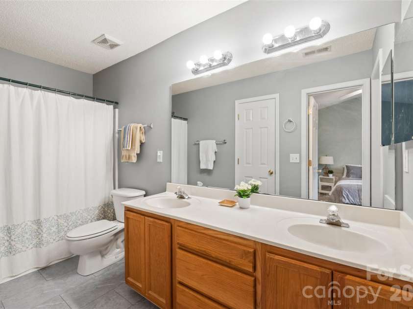 15411 Asterwind Court, Charlotte, NC 28277.  MLS# CAR4390329, YatesRealty ID 32878. Primary bathroom with updated floors, linen closet, double sinks and tub/shower combo.