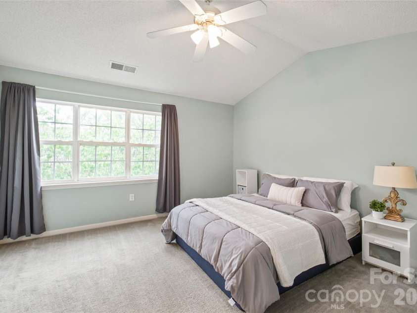 15411 Asterwind Court, Charlotte, NC 28277.  MLS# CAR4390329, YatesRealty ID 32878. Spacious primary bedroom featuring vaulted ceilings and a large window that fills the room with beautiful natural light.