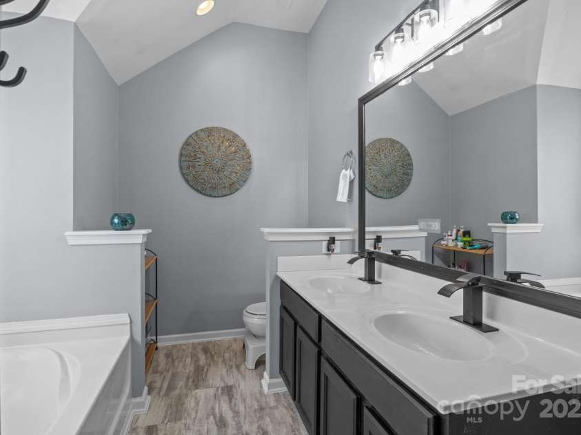 4205 Springhaven Drive, Charlotte, NC 28269.  MLS# CAR4275693, YatesRealty ID 32889. Gorgeous Primary bathroom w/ updated fixtures has new LVP flooring.