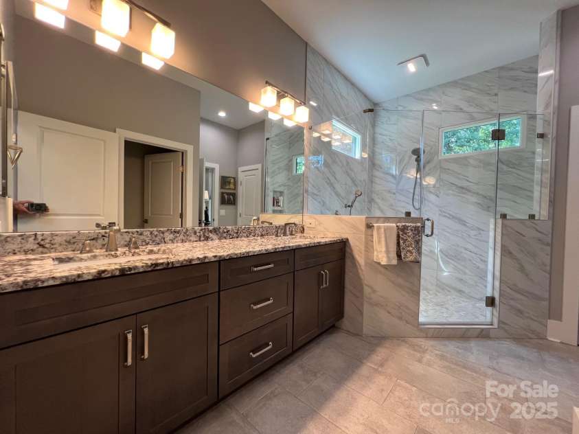 126 Redbud Lane, Troutman, NC 28166.  MLS# CAR4284135, YatesRealty ID 32890. The owners' bathroom has a long vanity for 2 and beautiful tile.