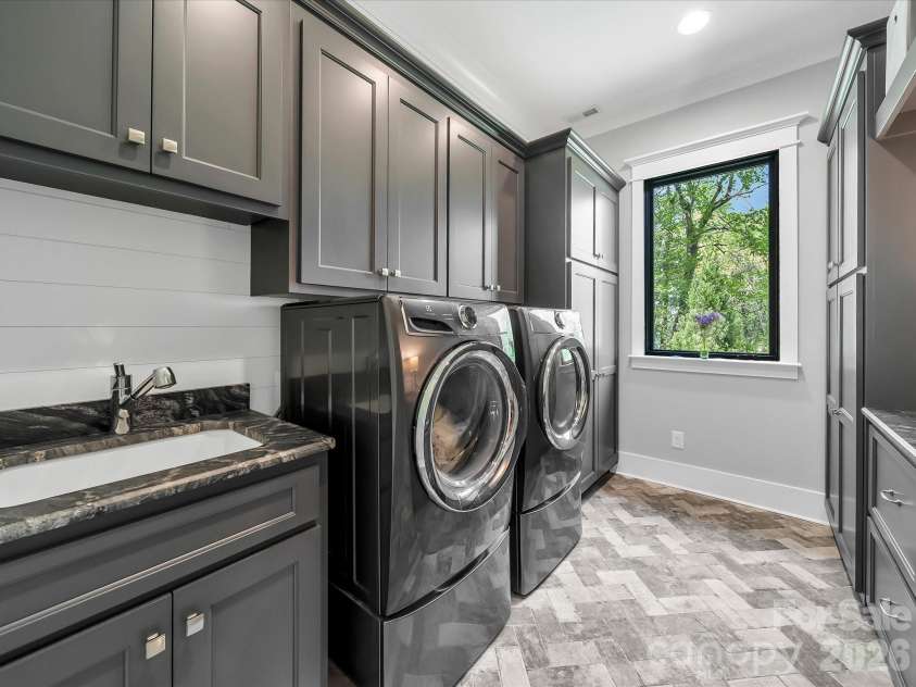 1579 Sunset Pointe Drive, Salisbury, NC 28146.  MLS# CAR4386995, YatesRealty ID 32928. Laundry Room with Custom Cabinets, Laundry Sink and Tile Floor