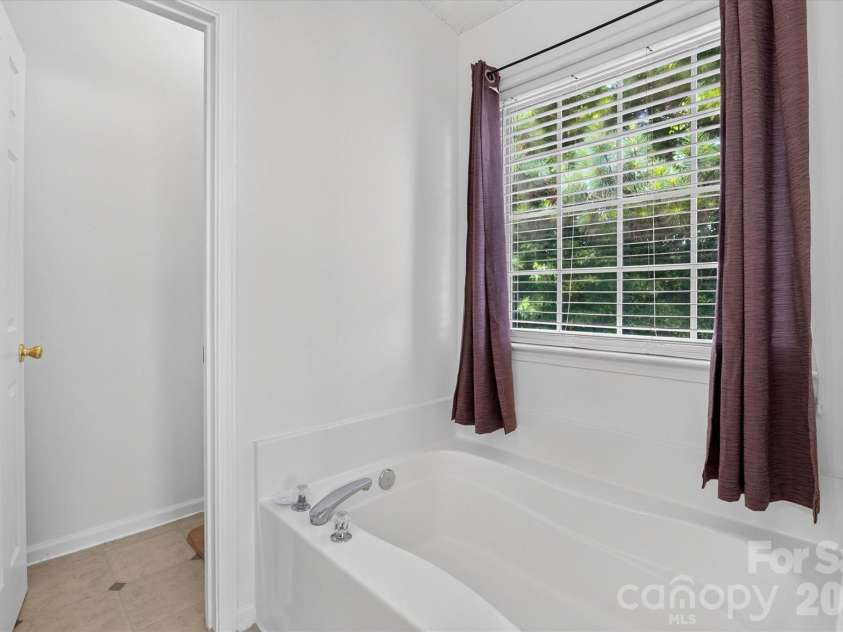 9833 Aventide Lane, Charlotte, NC 28215.  MLS# CAR4377310, YatesRealty ID 33061. Ensuite Bathroom with sunken bathtub and separate water closet