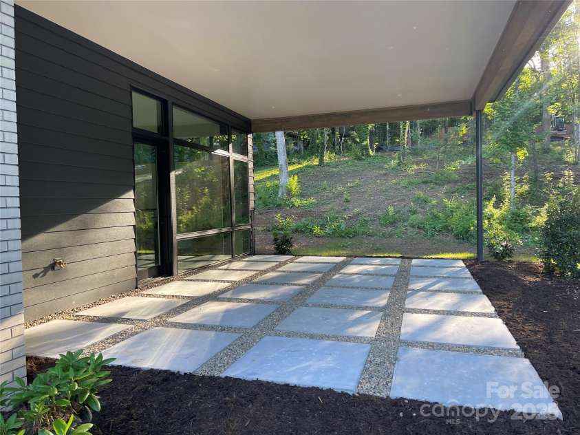 129 English Drive, Candler, NC 28715.  MLS# CAR4255359, YatesRealty ID 33098. Covered patio off primary bedroom