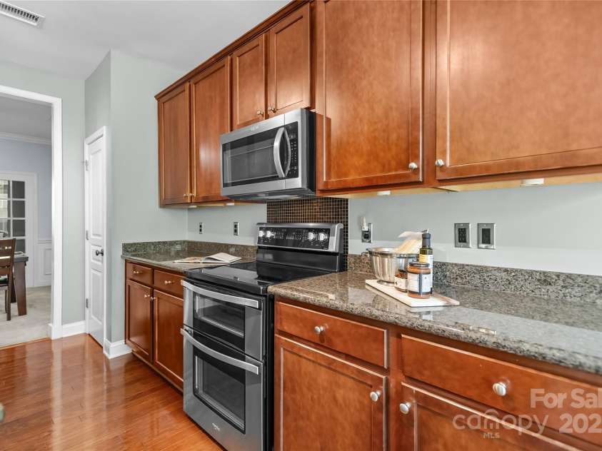9724 Cadman Court, Cornelius, NC 28031.  MLS# CAR4233696, YatesRealty ID 3312. Kitchen with granite counters, stainless steel appliances, plenty of cabinets for storage, pantry & breakfast area!
