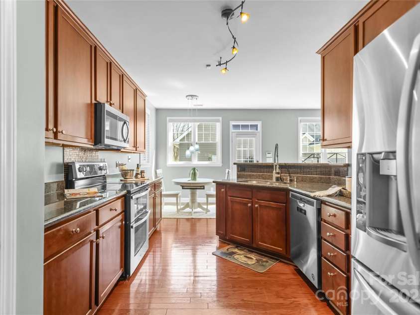 9724 Cadman Court, Cornelius, NC 28031.  MLS# CAR4233696, YatesRealty ID 3312. Kitchen with granite counters, stainless steel appliances, plenty of cabinets for storage, pantry & breakfast area!