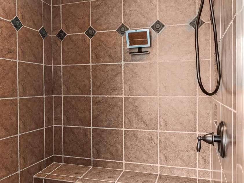 1040 Lake Forest Drive, Matthews, NC 28104.  MLS# CAR4285953, YatesRealty ID 33125. Primary Bath Tiled Shower and Bench