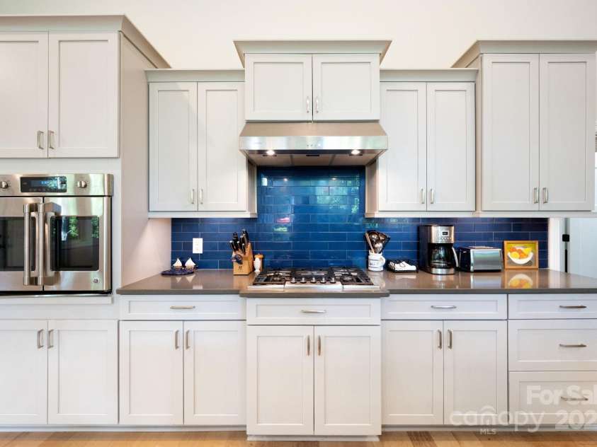 33 Penley Park Drive, Weaverville, NC 28787.  MLS# CAR4286490, YatesRealty ID 33176. Enjoy a well-appointed kitchen with a classic blue backsplash, gas cooktop, and generous cabinet space.
