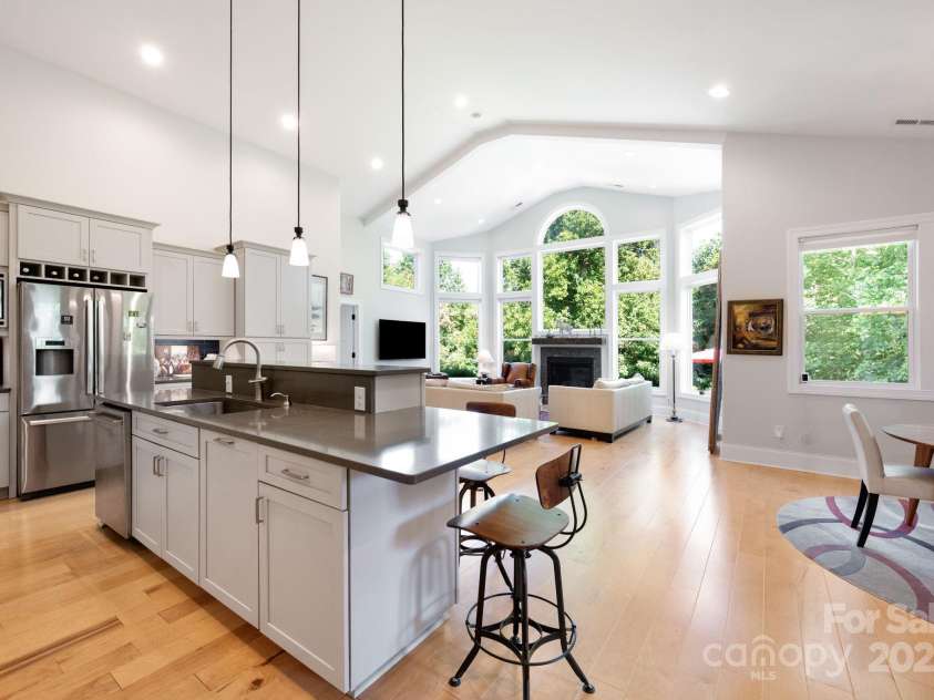 33 Penley Park Drive, Weaverville, NC 28787.  MLS# CAR4286490, YatesRealty ID 33176. The kitchen flows into the living area, where a wall of windows fills the space with natural light.