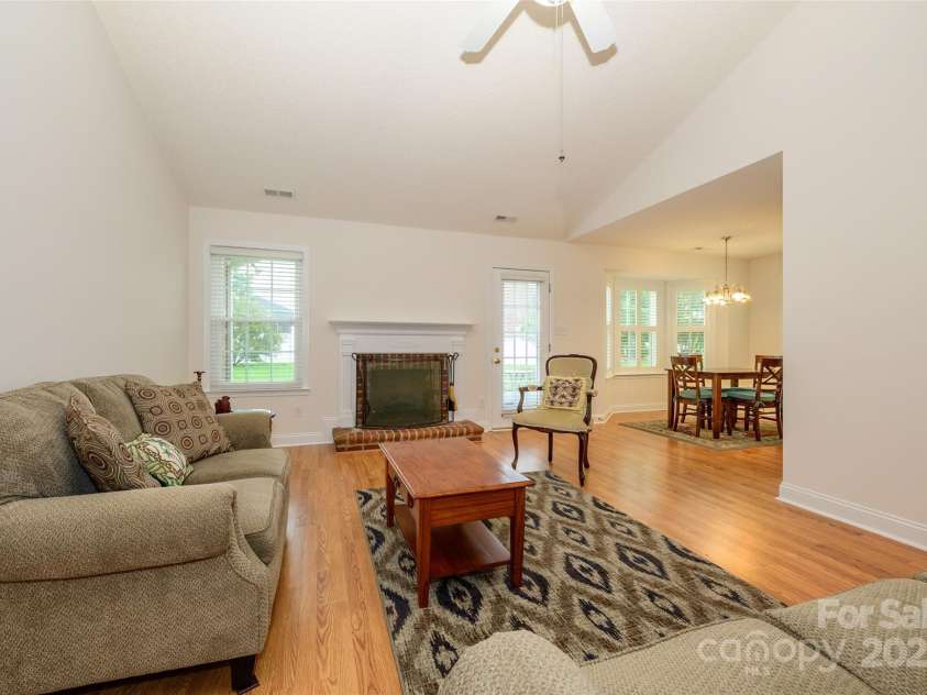 12617 Hill Pine Road, Midland, NC 28107.  MLS# CAR4291136, YatesRealty ID 33201. Open floor plan with laminate wood floors, vaulted ceilings, ceiling fan, and gas log fireplace.