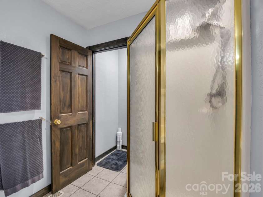 1025 Jeter Mountain Road, Penrose, NC 28766.  MLS# CAR4397105, YatesRealty ID 33202. Corner shower and water closet
