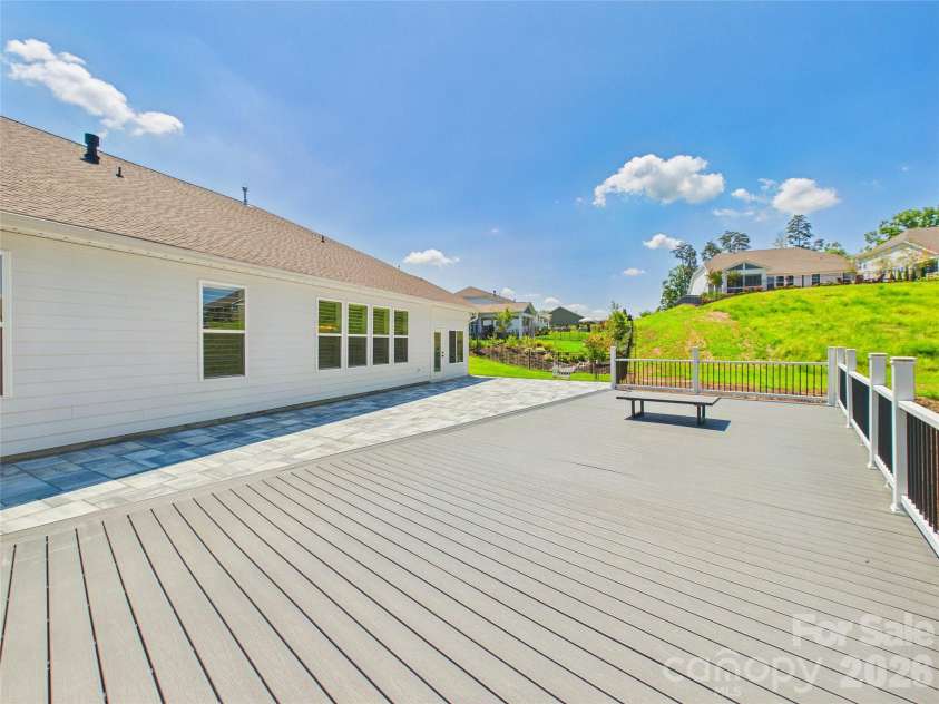 8027 Longwaters Court, York, SC 29745.  MLS# CAR4368751, YatesRealty ID 33228. The high-performance, low-maintenance composite material of this deck provides a sleek, durable surface for the dedicated dining area and multiple lounging spots. Surrounded by lush greenery and a modern railing system, t