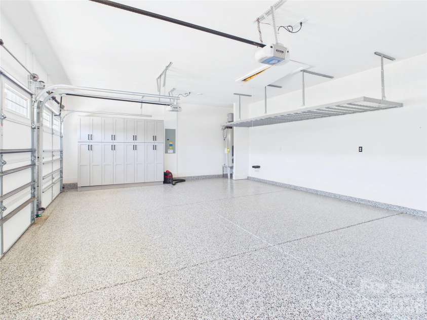 8027 Longwaters Court, York, SC 29745.  MLS# CAR4368751, YatesRealty ID 33228. This spacious three-car garage features durable, modern epoxy flooring that gives the room a sleek, polished finish. It offers exceptional organization solutions, including a large wall of built-in storage cabinets, a hea