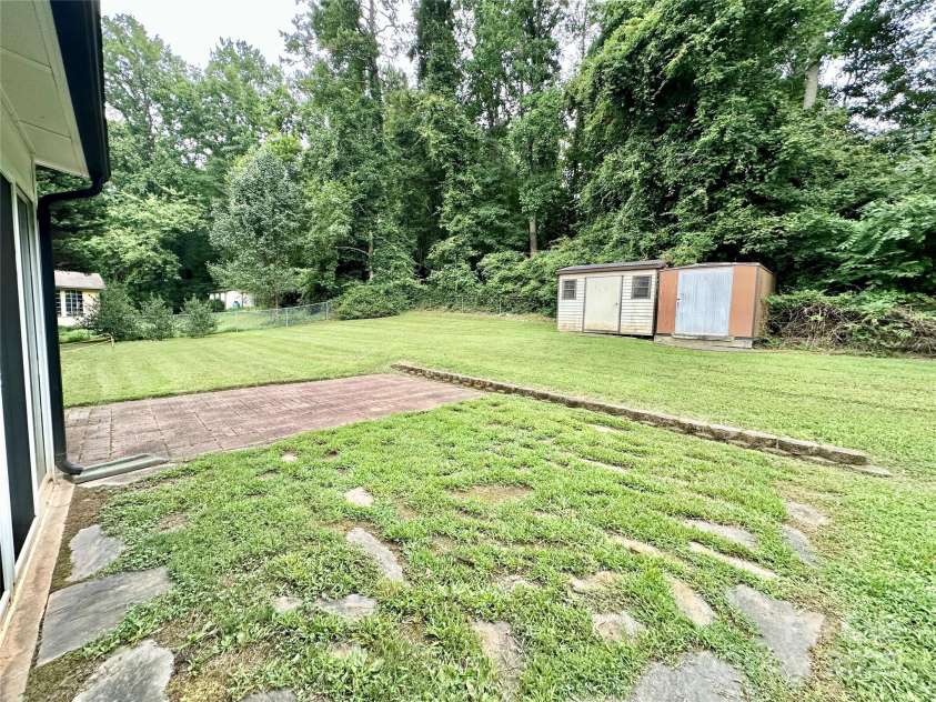 4705 Can Do Court, Gastonia, NC 28056.  MLS# CAR4287219, YatesRealty ID 33229. Back yard with two storage buildings and brick paver patio
