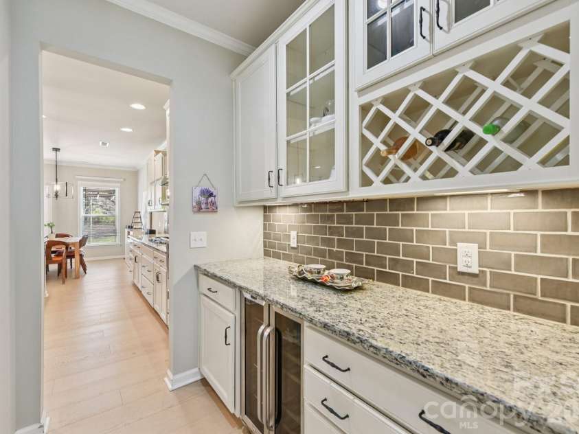 204 Hampton Trail Drive, Fort Mill, SC 29708.  MLS# CAR4350290, YatesRealty ID 33275. Butlers pantry with beverage refrigerator, tile backsplash, granite counters & decorative glass doors & cabinetry.
