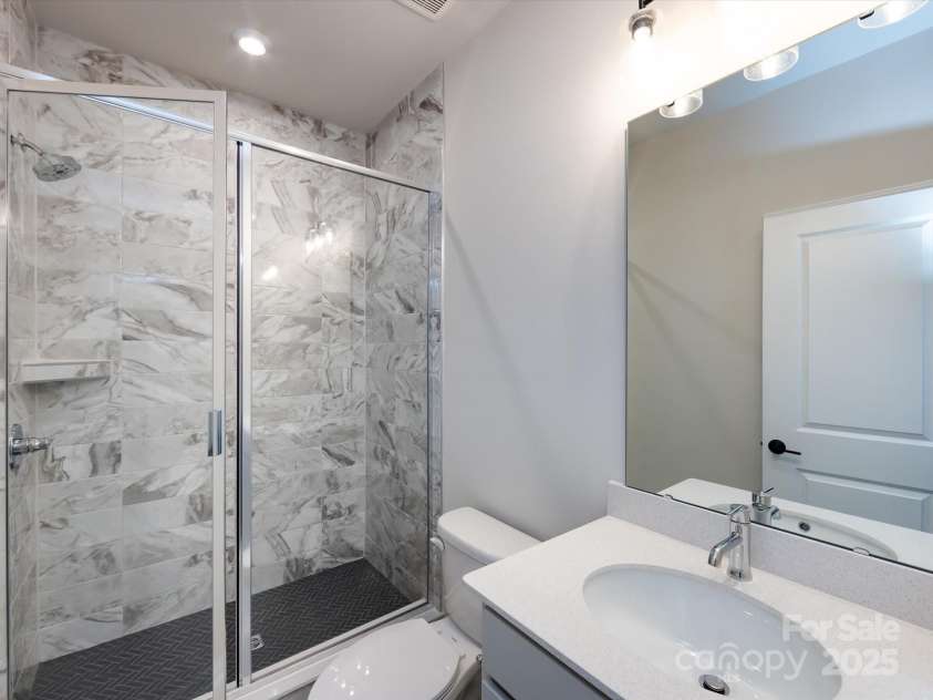 7023 Short Stirrup Lane, Mint Hill, NC 28227.  MLS# CAR4291701, YatesRealty ID 33286. First floor full bath with modern tiled walk-in shower.