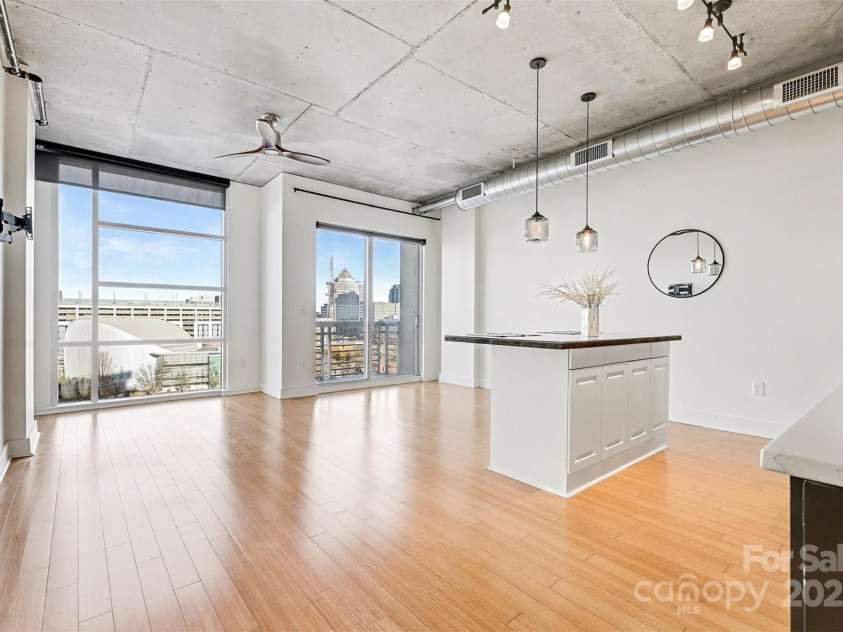 505 6th Street, Charlotte, NC 28202.  MLS# CAR4331119, YatesRealty ID 3329. Living Room – Skyline ViewExpansive floor-to-ceiling windows flood the space with natural light and frame sweeping Uptown views.