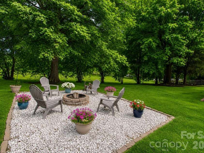 1015 Estate Lane, Matthews, NC 28104.  MLS# CAR4388127, YatesRealty ID 33333. Fire pit in the backyard perfect for entertaining.  Grass was enhanced with AI.  It shows what it could look like.