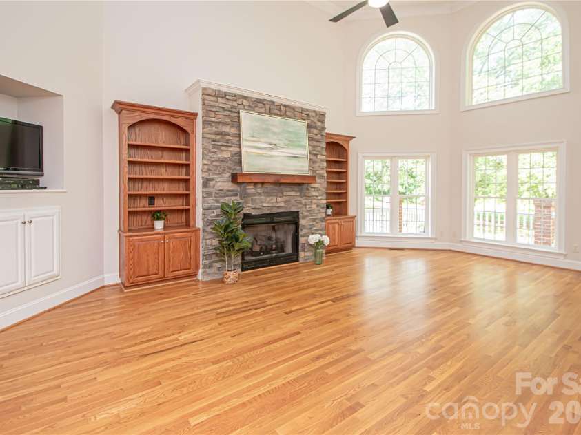1015 Estate Lane, Matthews, NC 28104.  MLS# CAR4388127, YatesRealty ID 33333. Great room has stone fireplace with bookcases at each side.