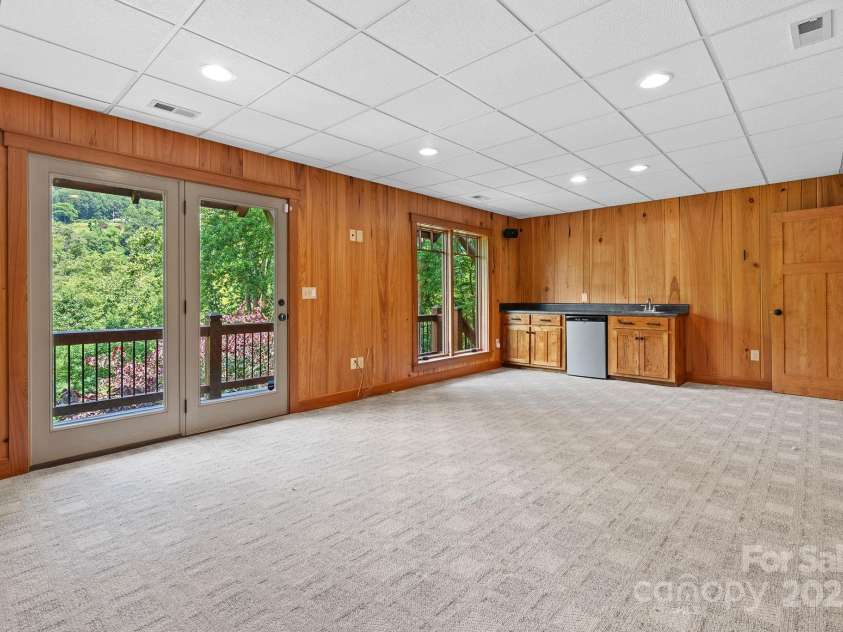 147 Brantley Branch Lane, Waynesville, NC 28786.  MLS# CAR4275100, YatesRealty ID 3349. Large rec room with wet bar and exit to lower level deck