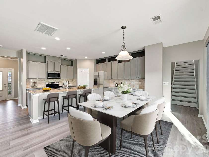 1855 Shadow Lawn Court, Fort Mill, SC 29715.  MLS# CAR4395925, YatesRealty ID 33513. (Virtually staged) Open kitchen and dining area with custom cabinetry, integrated lighting, and a large island, ideal for entertaining.