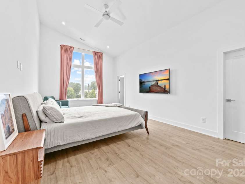 102 Mattoon Street, Charlotte, NC 28216.  MLS# CAR4291152, YatesRealty ID 33532. Primary bedroom with SOARING ceilings and a huge window with city skyline views.