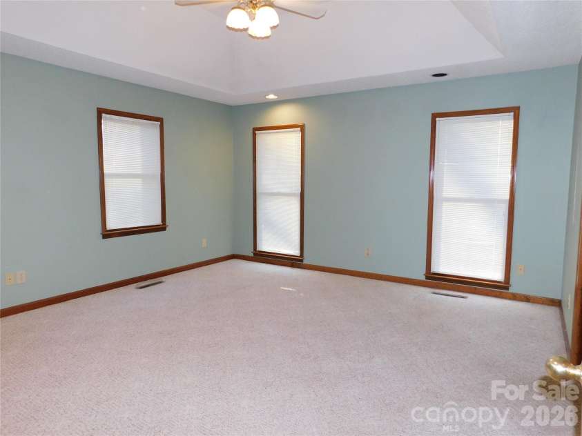 175 Briarfield Drive, Mooresville, NC 28115.  MLS# CAR4342091, YatesRealty ID 3356. Primary Bedroom 14.5x15  has a trey ceiling with recessed lights and ceiling fan Extra long windows frame this room with plenty of natural light