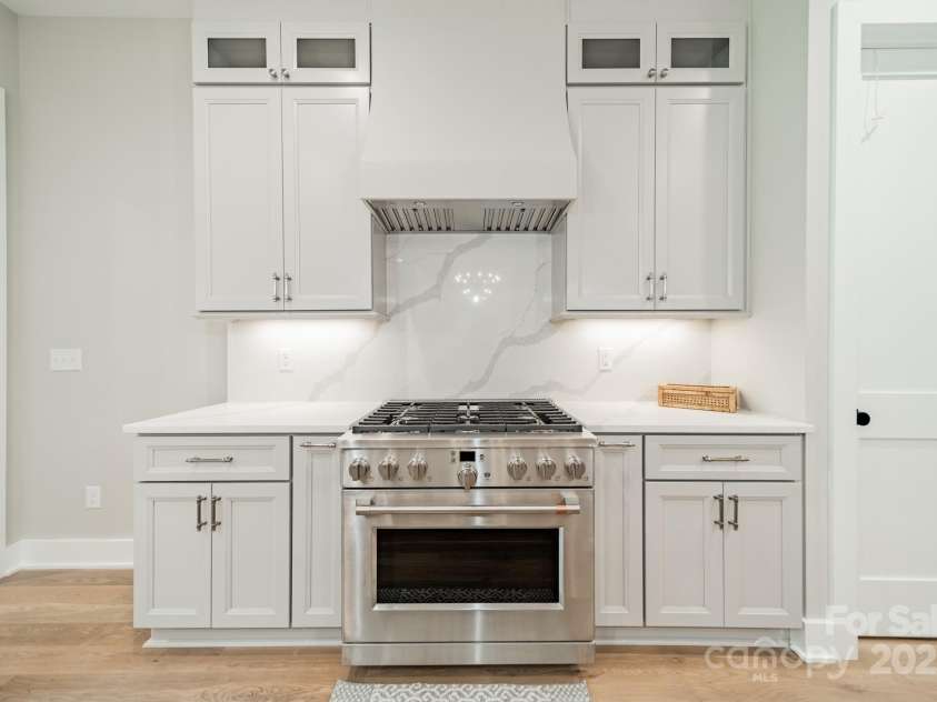 4028 Spindrift Cove Drive, Denver, NC 28037.  MLS# CAR4270075, YatesRealty ID 33617. Fabulous Chef's Kitchen with oversized Gas Range and Oven, Quartz Counter Tops and Backsplash, and Custom Cabinetry