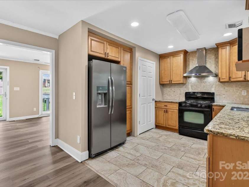 2221 Ludlow Drive, Charlotte, NC 28216.  MLS# CAR4292812, YatesRealty ID 33644. Alt View of Kitchen. The closet (to the left of the stove) is the laundry room, which comes with a stackable W+D set