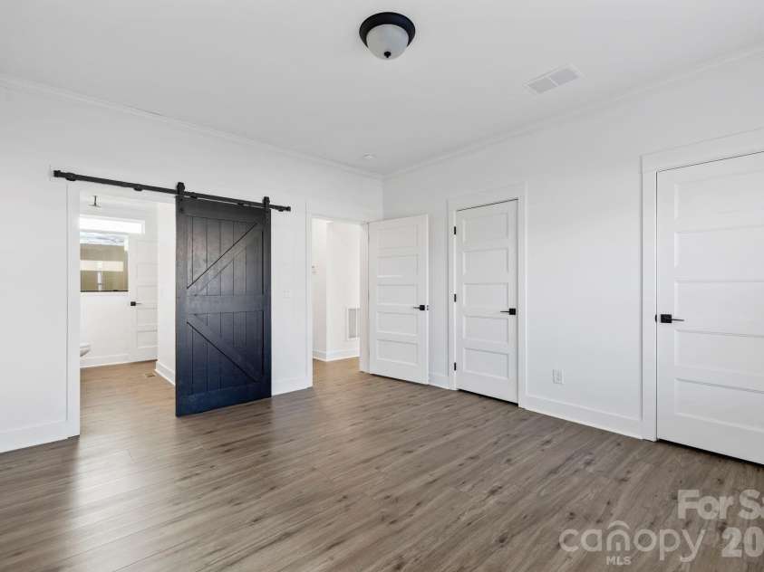 203 Southern Charm Road, Arden, NC 28704.  MLS# CAR4342838, YatesRealty ID 3365. Main Level Primary suite w/ 2 closets & Barn Door to Ensuite bathroom