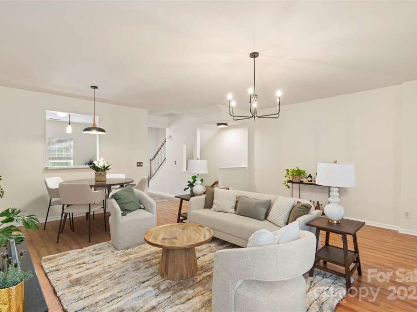 864 Tiger Lane, Charlotte, NC 28262.  MLS# CAR4278320, YatesRealty ID 33655. Bright and airy open-concept living and dining space featuring neutral tones, updated lighting, and rich wood-style flooring — perfect for both everyday living and entertaining.