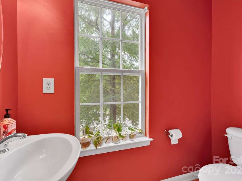 864 Tiger Lane, Charlotte, NC 28262.  MLS# CAR4278320, YatesRealty ID 33655. Cheery powder room  at base of stairs to the 3rd floor.