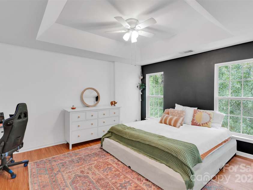 864 Tiger Lane, Charlotte, NC 28262.  MLS# CAR4278320, YatesRealty ID 33655. Retreat to your oversized primary suite featuring tray ceilings, large windows with wooded views, and room for a home office setup.