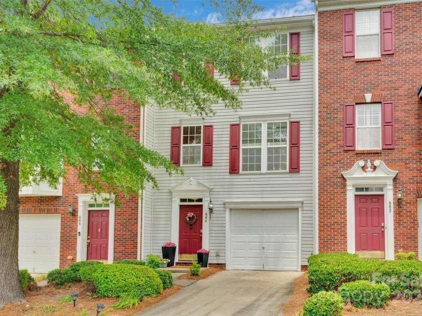 864 Tiger Lane, Charlotte, NC 28262.  MLS# CAR4278320, YatesRealty ID 33655. This classic tri level townhome features charming shutters, mature landscaping, and a one-car garage