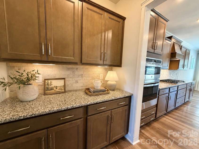 1318 Poppy Way, Matthews, NC 28104.  MLS# CAR4387809, YatesRealty ID 33740. The gourmet kitchen flows seamlessly into a spacious, expertly designed butler’s pantry, featuring extensive cabinetry and generous counter space. This versatile area is perfect for hosting, whether utilized as a sophisticat