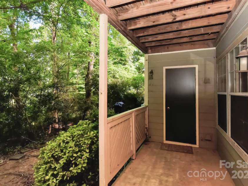 6500 Clavell Lane, Charlotte, NC 28210.  MLS# CAR4289455, YatesRealty ID 33760. Back covered patio w/light open to private wooded area and has a storage closet and new H20 heater (2021) inside closet.
