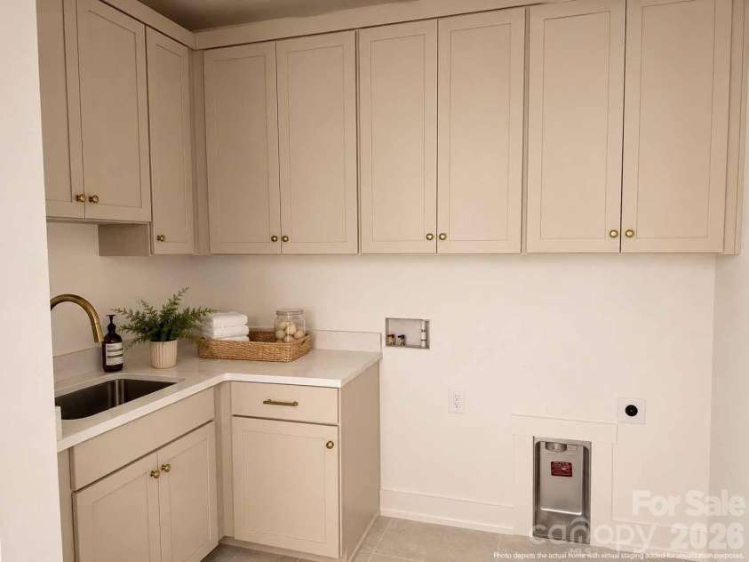 4337 Castleton Road, Charlotte, NC 28211.  MLS# CAR4329159, YatesRealty ID 33798. This utilitarian laundry room equipped with cabinets for storage and a sink for convenience. This photo has been virtually enhanced